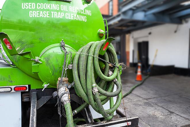 worker pumping grease trap at commercial kitchen in Bettsville OH